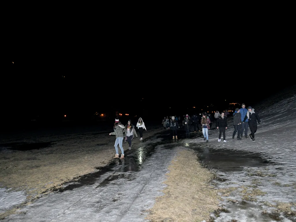 Gruppe geht abends über eine geräumte Straße durch den Ort.